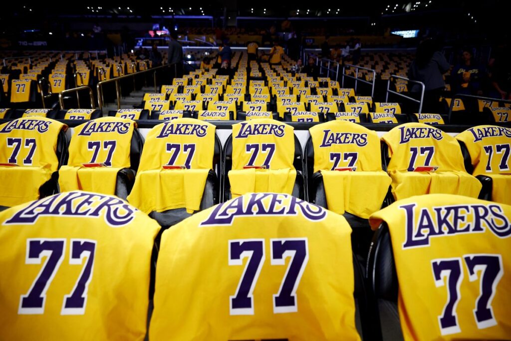 Liverpool and Lakers deals set new bar for sport investment Rows of yellow Lakers jerseys with 77 on seats in a dark basketball arena.